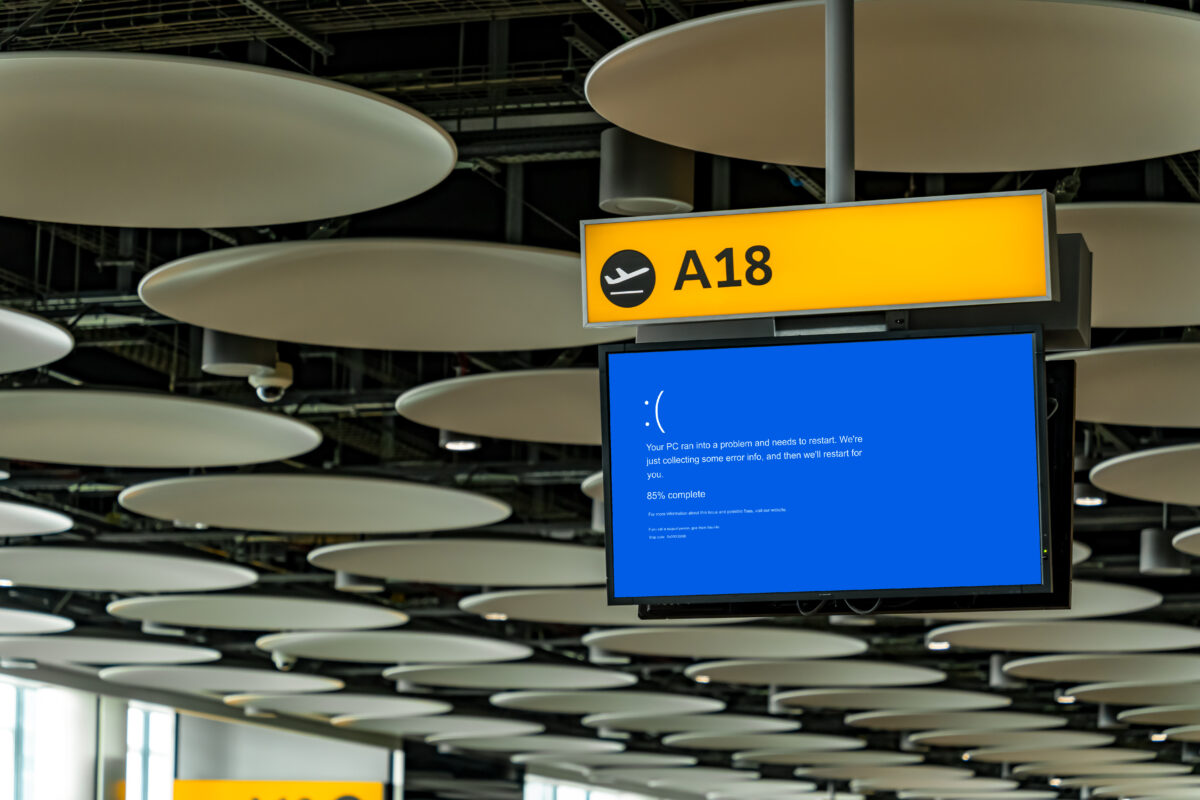 Windows 11 blue screen on an airport information board.