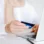 A woman holding her credit card to pay for an online purchase
